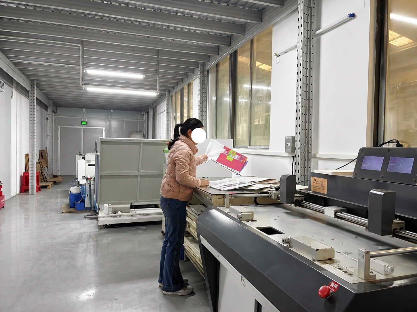 Operator reviewing printed sheets during finishing inspection